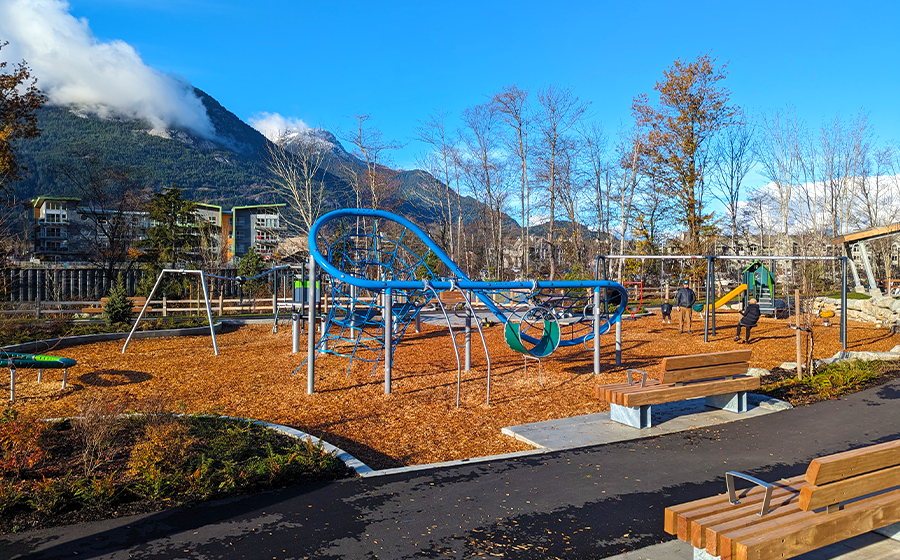 Vibrant playground at Waterfront Landing North Park in Squamish, BC, featuring KOMPAN play equipment and stunning mountain views