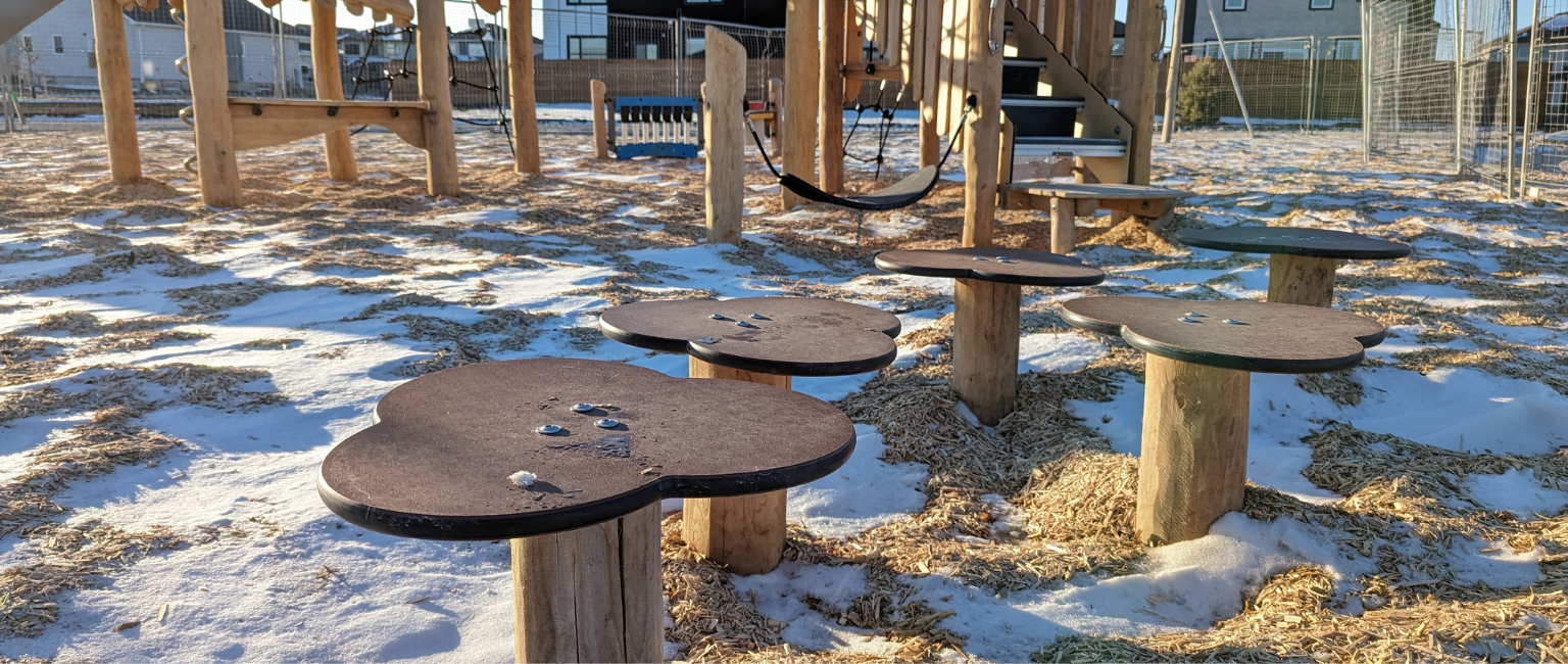 Wooden playground equipment in the snow during the winter