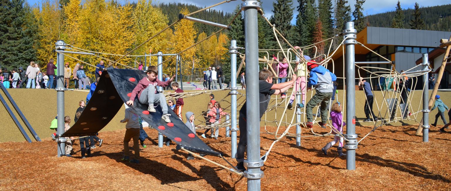 Kids playing on climbing playground structure in Sun Peaks, BC.