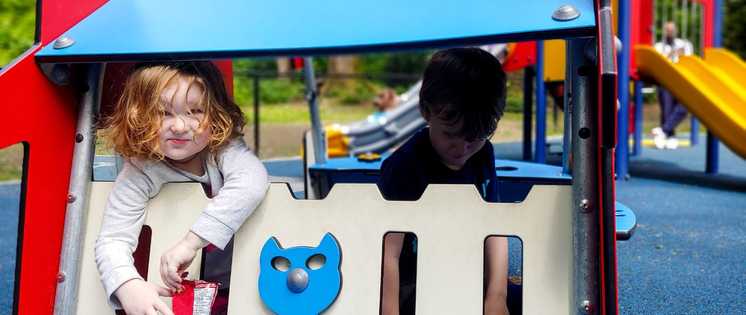Young girl in a KOMPAN play structure on the playground