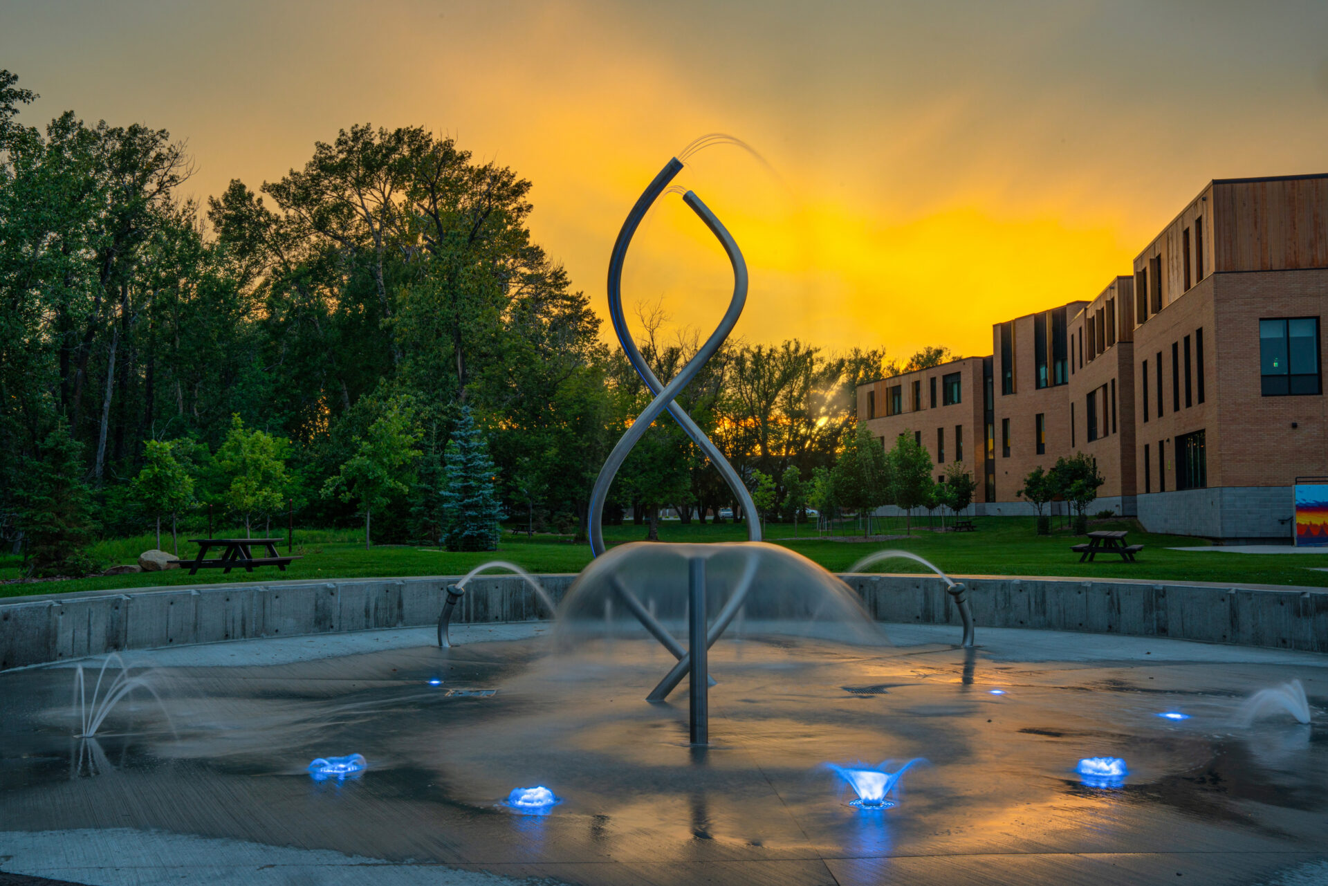 Twilight photo of splash pad water feature at the Okotoks Arts and Learning Campus