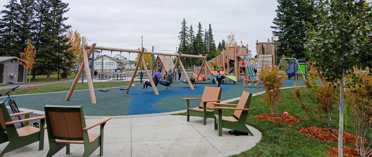 Comfortable seats in the foreground while kids play on the playground in the background